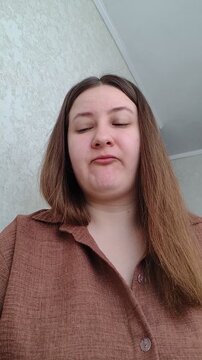 vertical video of plus size woman taking dissolvable tablet and showing it on tongue. everyday health routine, self-care and wellness concept. authentic lifestyle b-roll for healthcare and wellness ad