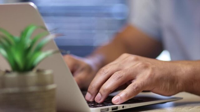 Close up of professional man typing on laptop keyboard, focusing on data protection, password entry, and cybersecurity measures in an office for online account safety