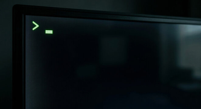 Glowing Green Cursor Blinking on a Dark Computer Monitor Screen