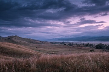 Obraz premium Atmospheric hill landscape at dusk with dramatic overcast sky in Esquel, Patagonia