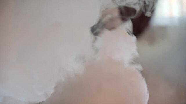 Close-up of artificial smoke moving in the air, atmospheric fog effect, abstract smoke texture, cinematic background with swirling white smoke, studio special effects, slow motion smoke video
