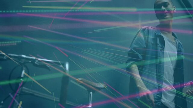 Man tapping cell starting music, tucking, taking bike, reaching kit to play under light streaks