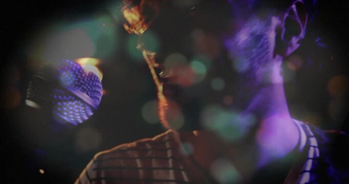 Male singer leaning into mic, singing, activating warm light and bokeh overlaying frame for music