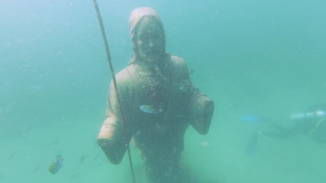 Underwater View of Cristo de las Profundidades Statue with Tropical Fish and Mooring Line in Turquoise Water at Playa Las Gatas Zihuatanejo Mexico