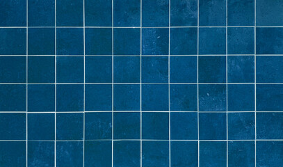 High-resolution texture of deep blue ceramic square tiles with clean white grout lines, perfect for modern interior design, bathroom wall backdrop, kitchen backsplash, or swimming pool background.