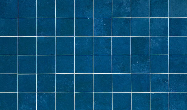 High-resolution texture of deep blue ceramic square tiles with clean white grout lines, perfect for modern interior design, bathroom wall backdrop, kitchen backsplash, or swimming pool background.