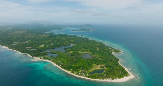 Island with turquoise sea water with waves. White beach, farmlands and lake. Santa Fe, Tablas, Romblon. Philippines.