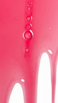 Close up triptych of glossy pink liquid dripping and forming beads on a white background, slow flowing paint or gel creating smooth arches and vertical droplets, abstract texture study