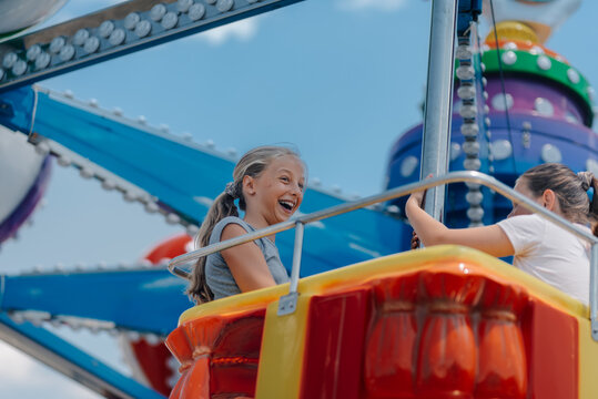 Happy girls having fun on a swing ride at amusement park