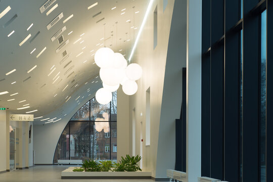 Modern hospital atrium interior with large windows and minimalist architecture.
