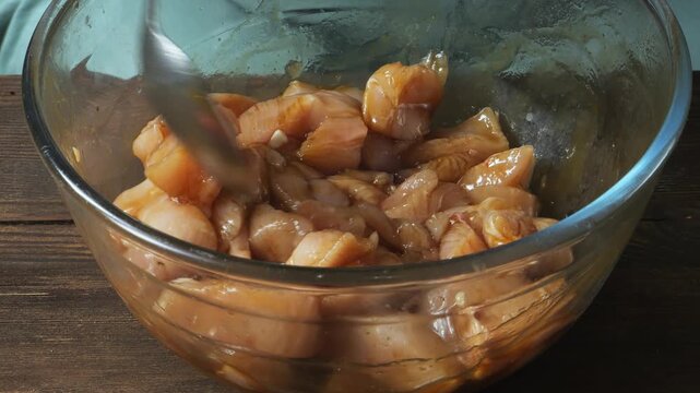 Chicken fillet marinated in teriyaki sauce with spices and garlic in a glass bowl. Close-up.