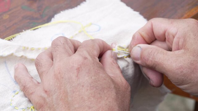 Hands Sewing and Embroidering Fabric with Needle and Thread Showcasing Traditional Craftsmanship and Intricate Textile Details