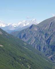 Obraz premium Alpine landscape with green forest valley and snowy mountains