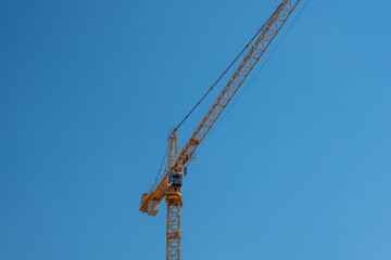 Yellow Tower Crane Against a Clear Blue Sky