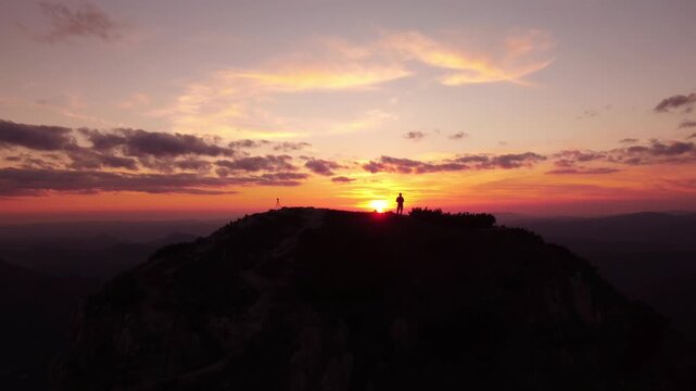 Person on mountain top at sunset - aerial view