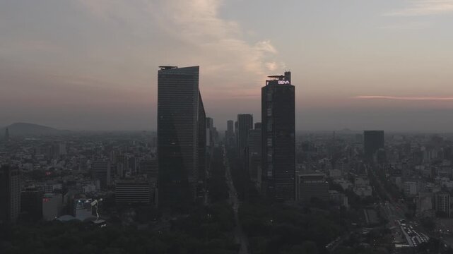 Aerial reveal at sunrise over Castillo de Chapultepec with drone ascending to unveil Paseo de la Reforma skyline, Mexico City