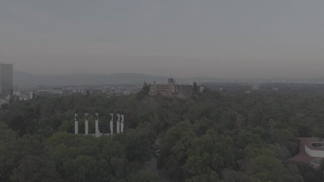 Aerial drone flying forward over Altar a la Patria towards Castillo de Chapultepec at sunrise in Bosque de Chapultepec, M&eacute;xico City. Shot in D-Log M