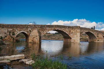 Fototapeta premium The medieval bridge Pont Vell (12th century), in the town of Montblanc, Catalonia, Spain, spans the Francoli River. Low camera standpoint. 