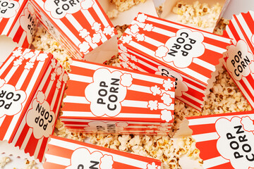 Fototapeta premium Overhead view of paper popcorn containers with striped pattern and popcorn texture background representing entertainment and leisure activity