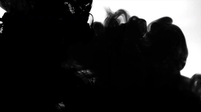 Black smoke rising fast Silhouettes of people against light background