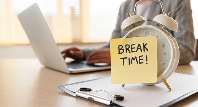 Person taking a break from work, with an alarm clock and 'Break Time!' note on desk.
