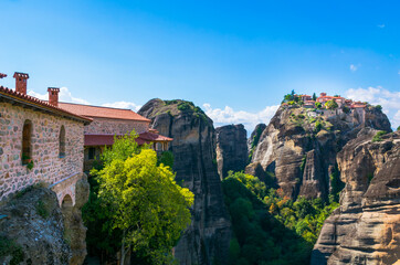 Fototapeta premium Panoramic view form The Holy Monastery of Varlaam to The Holy Monastery of Great Meteoron sitting atop sandstone pillar in Meteora, Thessaly, Greece