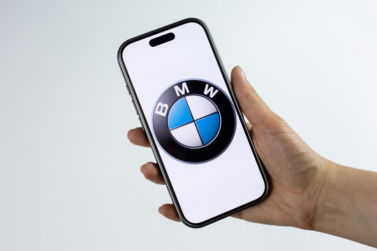 Moscow, Russia, March 14, 2026: Smartphone in hand showing BMW logo on display, on white background. Image representing electric mobility future, EV transition and Neue Klasse electric vehicles