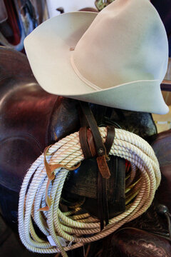 Santa Fe, New Mexico, United States. Vintage western saddle with coiled rope and cowboy hat ranch scene