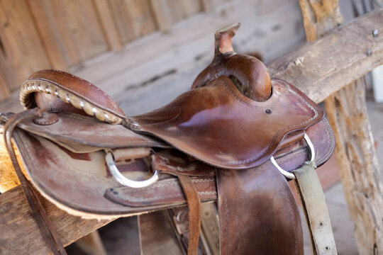 Tucson, Arizona, United States. Western leather saddle on wooden rack at ranch stable