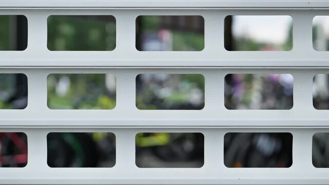 White metal roller shutter with geometric pattern and blurred background with bokeh