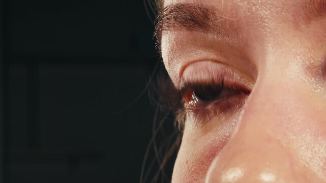 Close-up womans blinking eye with long eyelash and contact lens. Beauty make up of green eye with neon light.