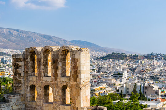 Upper arches of the ancient Theatre of Dionysus below the Acropolis hill with city of Athens in the distance, Attica, Greece