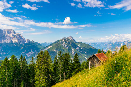 Panoramic view of Italian Alps with small wooden barn on a steep meadow above Tarvisio, Friuli Venezia Giulia region, Italy
