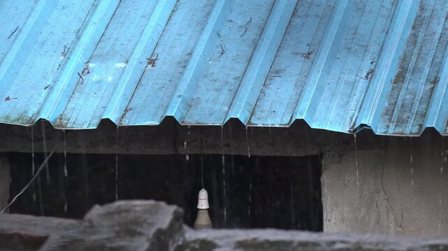 Raindrops Falling from Blue Corrugated Tin Roof During Heavy Monsoon Rain. Indian Monsoon Rain Pours in a Traditional Indian Village. Heavy Rainfall During Southwest Monsoon.