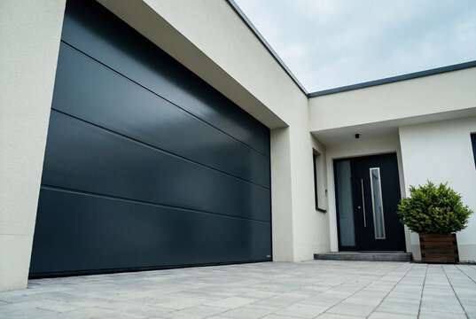 Modern residential house exterior with dark grey garage door