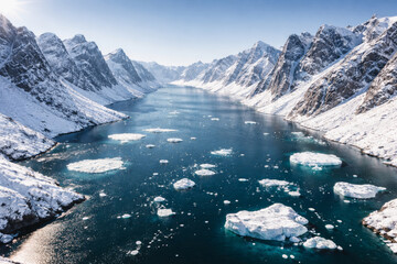 Obraz premium Majestic snowy mountains surrounding a calm blue glacial river