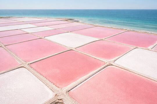 Pink and white salt pans by the beautiful blue ocean