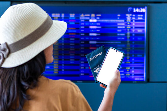 Solo female traveler checking flight schedule at airport