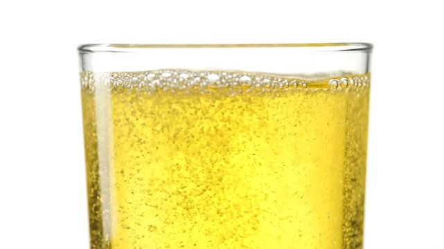 Glass of fizzy yellow soda drink.