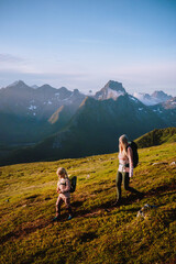 Naklejka premium Family summer vacations in Norway mother hiking with child outdoors travel active healthy lifestyle - parent and kid explore mountain trails in Lofoten Islands adventure trip together eco tourism