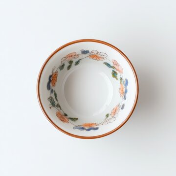 Top view of elegant porcelain bowl with delicate floral rim pattern on clean neutral background in minimalist product photography style