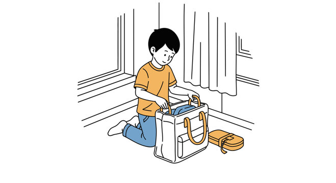 Young boy packing his school bag with care.