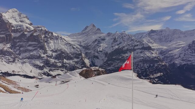 Cinematic shot of the Swiss flag with the Eiger, Monch, and Jungfrau peaks in background.