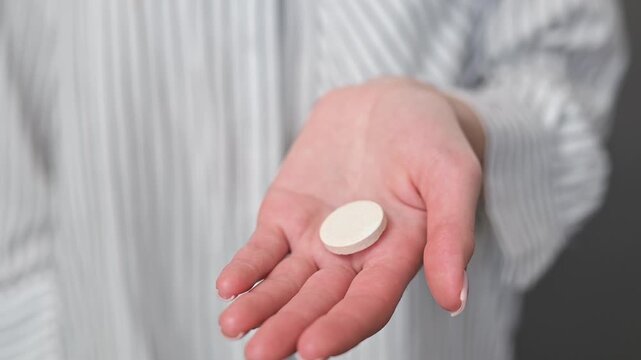A person shows a flat white tablet in their hand from various angles.