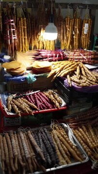 Vertical screen traditional churchkhela sweets hanging and displayed on market stall colorful natural desserts with nuts and grape juice local cuisine food concept
