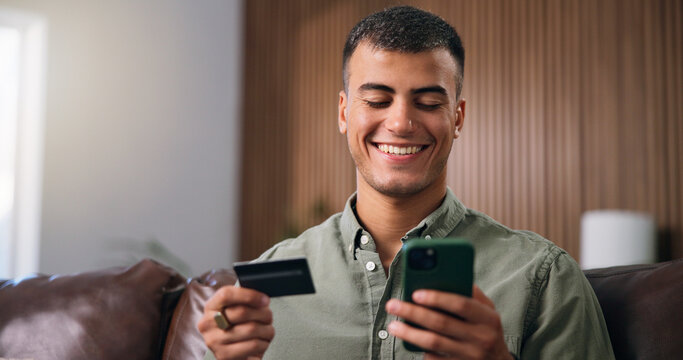 Credit card, smartphone and man on sofa in home with online shopping, ecommerce or purchase on website. Technology, debit and male person with phone for paying bills with internet banking in house.