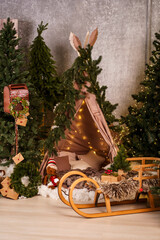 Cozy children's Christmas teepee with fairy lights, wooden sled and holiday decor © Minakryn Ruslan 