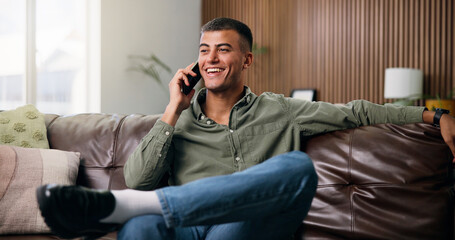 Fototapeta premium Man, phone call and relax on couch with smile, happy and chat or gossip in home living room. Person, smartphone and conversation on sofa with social networking, communication and speaking in lounge