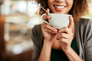 Smiling woman holding hot beverage in cafe