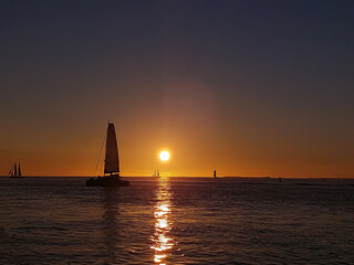 Sails at Twilight: Silhouetted Ships on the Horizon During a Key West Sunset © Rob